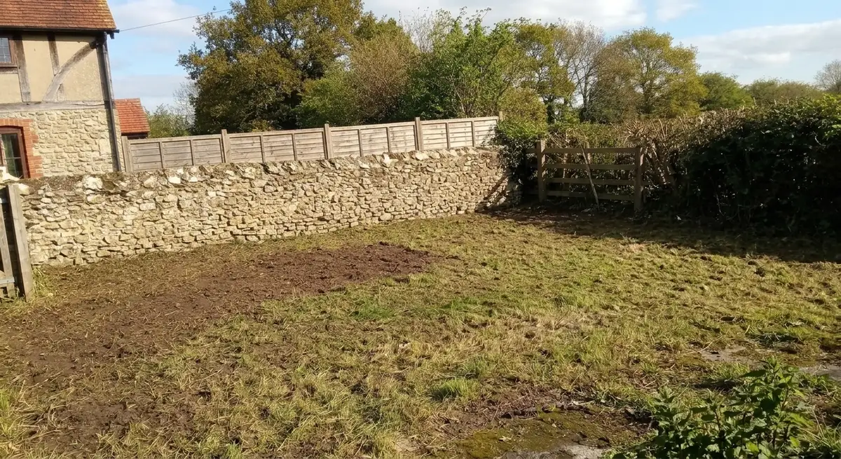 Après : terrain débroussaillé, mur de pierre dégagé